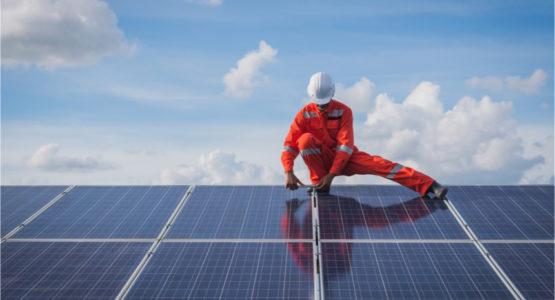 Man installing solar panels on a roof