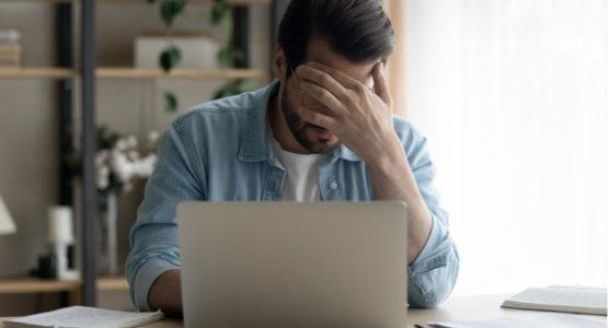 Man is stressed while looking at his laptop