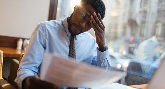 Man worried looking at his resume