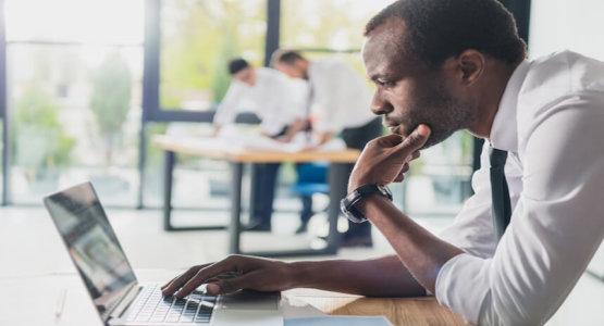 Man staring at his laptop while at his work