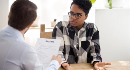 Employer reviewing resume in front of candidate