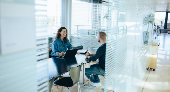 a man and woman talking in a conference room