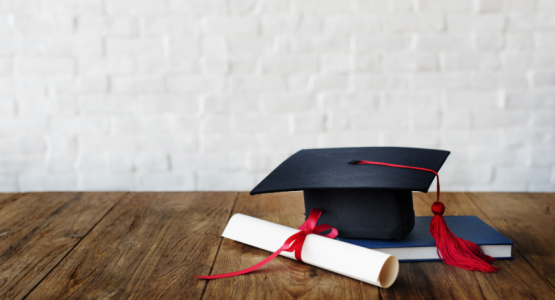 graduate cap and a diploma resting on table